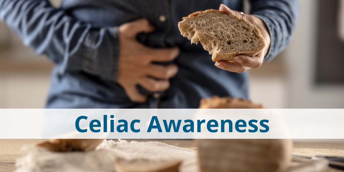person holding stomach with one hand and bread in the other